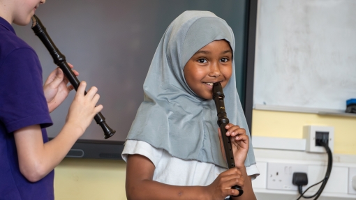 A young girl playing recorder