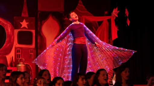 Boy on stage singing in costume