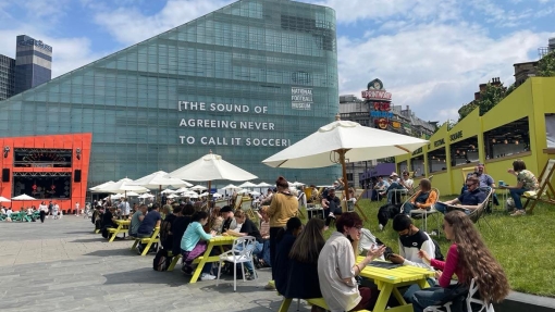 Students from Bolton sitting outside a cultural venue 