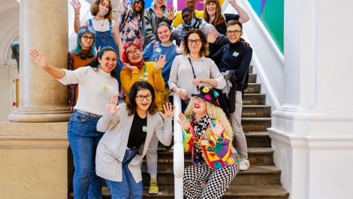 Anne Appelbaum standing on stairs in a museum with the Arts Council's Youth Advisory Board members