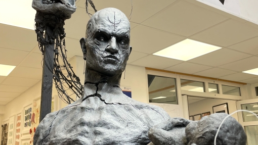 A large sculpture of a mans head and chest. 