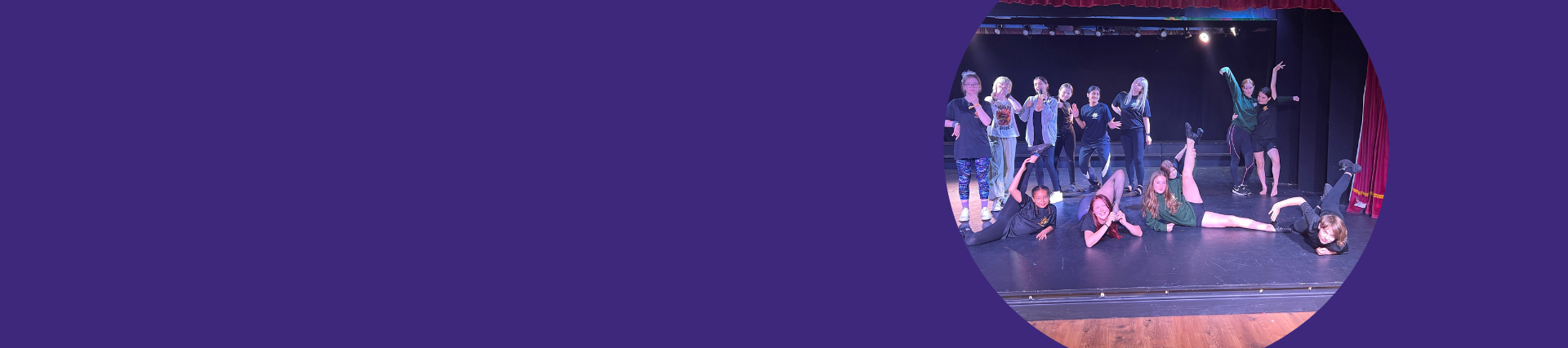 A group of young people pose in dance positions on a small stage.