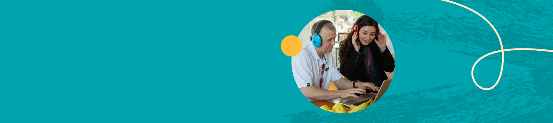 Two teachers wearing headphones looking at a laptop