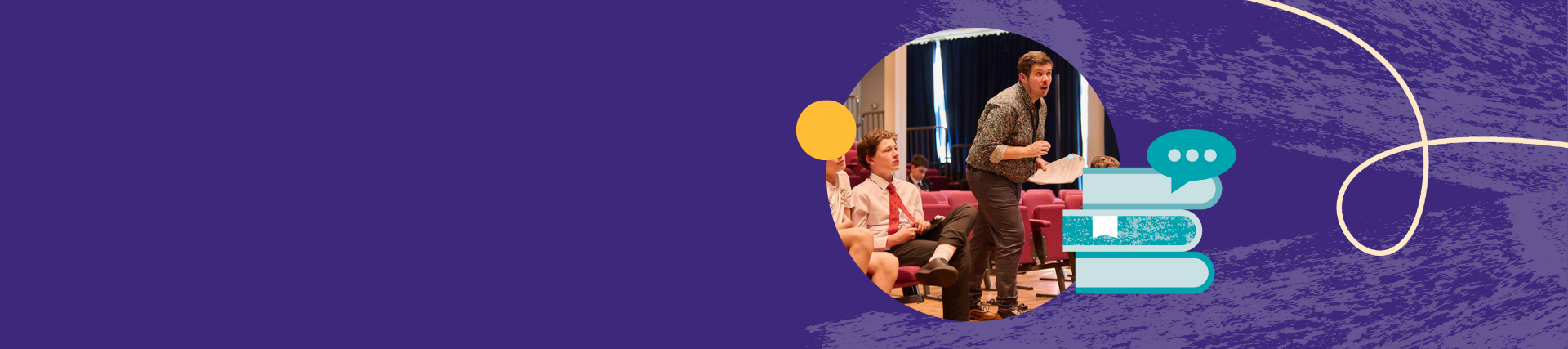 Three students are seated in an auditorium, with a teacher standing beside them holding papers giving directions.