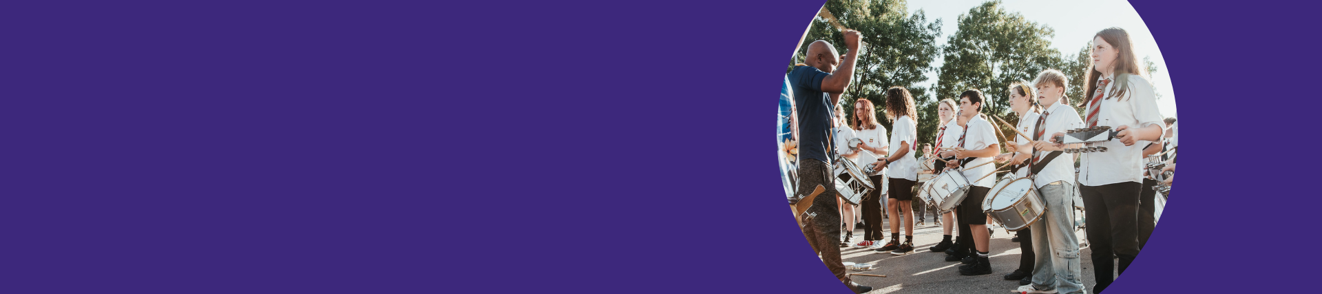 A purple banner with a group of students playing instruments outside.