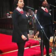 Two female students singing on stage into microphones