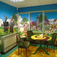 A creative corner of Race Leys Junior School's library with vibrant colourful walls and a table and chairs in the corner 