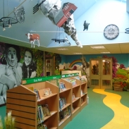 Race Leys Junior School library with Wizard of Oz themed wall mural and a yellow brick road on the floor leading to book shelves