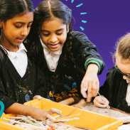 Three young girls paint around a table