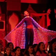 Boy on stage singing in costume