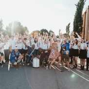 A group photo taken outside of students and staff all cheering.